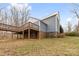 Rear view of the house showing a large deck and the house's gray shingle and brick exterior at 262 Vermont Dr, Stanley, NC 28164