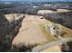 Wide aerial view of the property with fields, trees, home, and barn at 28926 Hartsell Rd, Albemarle, NC 28001