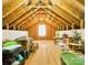 Attic featuring exposed wood rafters, plywood subfloor, and a small bright window at 28926 Hartsell Rd, Albemarle, NC 28001