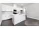 Bright kitchen boasts white cabinets, a central island, modern appliances, and elegant backsplash tile at 3105 Beacon Heights Rd, Indian Land, SC 29707