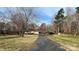 A ranch-style house with a long driveway, covered carport and a spacious front lawn dotted with mature trees at 350 Brawley Rd, Cleveland, NC 27013