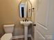 Charming powder room featuring a pedestal sink, decorative mirror, and modern fixtures at 3667 Travertine Dr, Lancaster, SC 29720