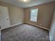 Bright bedroom features neutral walls, plush carpet, and a window with outdoor views at 3667 Travertine Dr, Lancaster, SC 29720