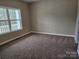 Cozy carpeted bedroom featuring a large window with natural light and a neutral color scheme at 3667 Travertine Dr, Lancaster, SC 29720