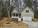 Inviting two-story home featuring a covered porch, attached garage, and classic design elements nestled amongst mature trees at 3667 Travertine Dr, Lancaster, SC 29720