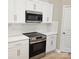 Modern kitchen with stainless steel appliances, white cabinets, and a tiled backsplash at 3667 Travertine Dr, Lancaster, SC 29720