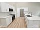 Open kitchen with stainless steel appliances, white cabinets, and light hardwood flooring at 3667 Travertine Dr, Lancaster, SC 29720