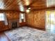 Cozy living room features wood-paneled walls, fireplace, large rug, and ample natural light from multiple windows at 3672 Nc Hwy 127 Hwy, Hickory, NC 28602