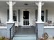 Inviting front porch featuring decorative columns, gray-painted deck, and charming furnishings at 412 E Ross Grove Rd, Shelby, NC 28150