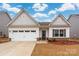 Charming single-Gathering home showcasing a white garage door and stone veneer accents at 4427 Allenby Pl, Monroe, NC 28110