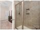 Walk-in shower with tiled surround, niche, and glass door at 4427 Allenby Pl, Monroe, NC 28110