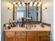 Well-lit bathroom featuring a double sink vanity with warm wood cabinetry at 4710 Nijinsky Ct, Charlotte, NC 28216