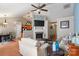 Cozy living room with fireplace, modern fan, and a seamless transition to the dining area at 4710 Nijinsky Ct, Charlotte, NC 28216