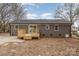 The exterior elevation of the home is gray brick, with a small wooden deck and a large concrete patio at 510 Colony Acres Dr, Charlotte, NC 28217