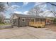 The exterior elevation of the home is gray brick, with a small wooden deck and a large concrete patio at 510 Colony Acres Dr, Charlotte, NC 28217