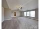 Spacious bedroom with neutral walls, soft carpet, three windows, and vaulted ceiling at 5513 Hammermill Dr, Harrisburg, NC 28075