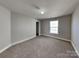 Bedroom with soft carpet, neutral walls, bright window, and an adjacent closet at 5513 Hammermill Dr, Harrisburg, NC 28075