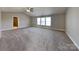 Large bedroom features neutral walls, soft carpet, three windows, and a ceiling fan at 5513 Hammermill Dr, Harrisburg, NC 28075