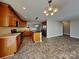 Open kitchen features brown cabinets, black appliances, an island, and decorative overhead lighting at 5513 Hammermill Dr, Harrisburg, NC 28075