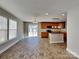 Open-concept living space with a modern kitchen island, tile floors, and natural light at 5513 Hammermill Dr, Harrisburg, NC 28075