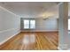 Spacious open living room with hardwood floors, chair railing, and natural light at 5513 Hammermill Dr, Harrisburg, NC 28075