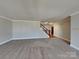 Large living room with a staircase, neutral carpeting, and ample space at 5513 Hammermill Dr, Harrisburg, NC 28075