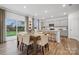 Well-lit dining area featuring a modern table, chairs, and access to a gray kitchen with a bar at 554 Mountain View Dr, Monroe, NC 28110