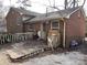 A rear view of a brick home with a partially covered entrance, and a raised wood deck at 5635 Ruth Dr, Charlotte, NC 28215
