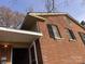 A side view of a brick home with a partially covered entrance with blue sky overhead at 5635 Ruth Dr, Charlotte, NC 28215