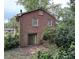 Rear view of a two-story brick home featuring an exterior door and mature landscaping at 5635 Ruth Dr, Charlotte, NC 28215