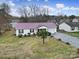 Exterior view of the home featuring updated siding, a long driveway and mature trees at 609 Ben Rich St, Dallas, NC 28034
