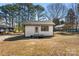 Exterior of a white home, shed, and carport in a grassy yard with mature trees at 627 Westway Dr, Gastonia, NC 28054