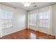 Bedroom with hardwood floors, two windows and light-colored drapery at 7147 Brighton Park Dr, Mint Hill, NC 28227
