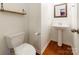 Charming half bathroom featuring hardwood floors, modern fixtures, and a pedestal sink at 7147 Brighton Park Dr, Mint Hill, NC 28227