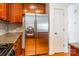 Kitchen featuring stainless steel refrigerator, granite counters, and wooden cabinets at 7147 Brighton Park Dr, Mint Hill, NC 28227
