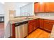 Well-lit kitchen featuring granite counters, wood cabinets, stainless steel dishwasher, and tile backsplash at 7147 Brighton Park Dr, Mint Hill, NC 28227