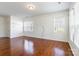Inviting living room featuring gleaming hardwood floors, bright natural light, and fresh, neutral paint at 7147 Brighton Park Dr, Mint Hill, NC 28227