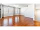 Bright living room with multiple windows, hardwood floors, and a staircase at 7147 Brighton Park Dr, Mint Hill, NC 28227
