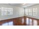 Spacious living room featuring beautiful hardwood floors, sun-filled windows, and fresh paint at 7147 Brighton Park Dr, Mint Hill, NC 28227