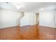Open-concept living room with gleaming hardwood floors and a staircase leading upstairs at 7147 Brighton Park Dr, Mint Hill, NC 28227