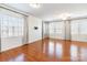 Bright living room featuring hardwood floors and large windows with modern coverings at 7147 Brighton Park Dr, Mint Hill, NC 28227