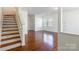 Bright living room with gleaming hardwood floors and staircase providing open space at 7147 Brighton Park Dr, Mint Hill, NC 28227