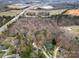 An aerial view of wooded lots near stores and highways, highlighting a residential community at 7219 Morningdew Ct, Denver, NC 28037