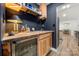 Stylish wet bar with wooden cabinets, sink, decor and a compact beverage refrigerator at 7219 Morningdew Ct, Denver, NC 28037