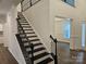 Staircase with elegant black railing and trim overlooking a room with a modern design at 8231 Annsborough Nw Dr, Concord, NC 28027