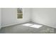 This bedroom has neutral carpet and trim and a window allowing natural light at 844 Westminster Dr, Statesville, NC 28677