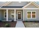Welcoming front porch with white columns, a dark-colored door, and well-kept landscaping at 844 Westminster Dr, Statesville, NC 28677