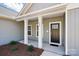 Inviting front porch with white columns, a dark-colored door, and tidy landscaping at 844 Westminster Dr, Statesville, NC 28677