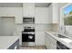 Close-up of kitchen featuring stainless steel appliances, white cabinets, and subway tile backsplash at 844 Westminster Dr, Statesville, NC 28677