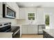 Close-up of the kitchen with stainless steel appliances, white cabinetry, and backsplash at 844 Westminster Dr, Statesville, NC 28677